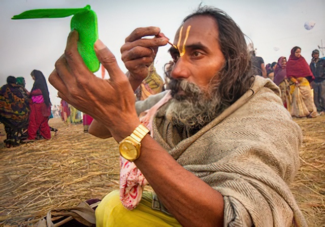 Holy Sadhu painting his face. by Laurie Bergner